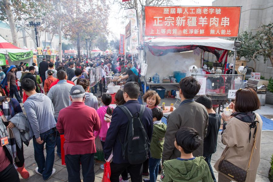 Food vendor tent along a palm-lined outdoor street