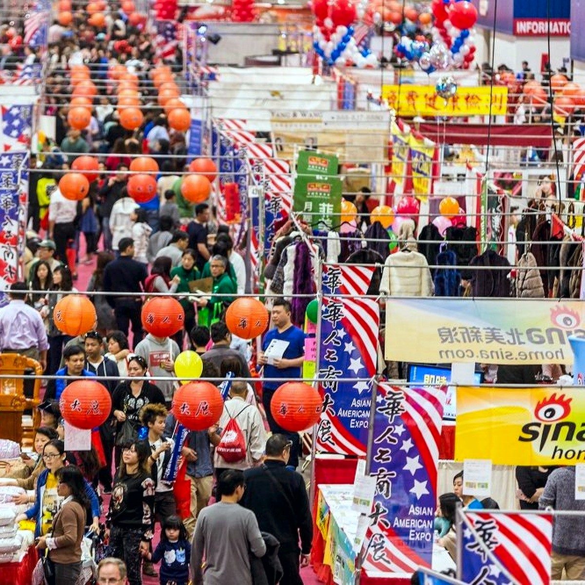 Packed exhibit hall aisle with lanterns overhead