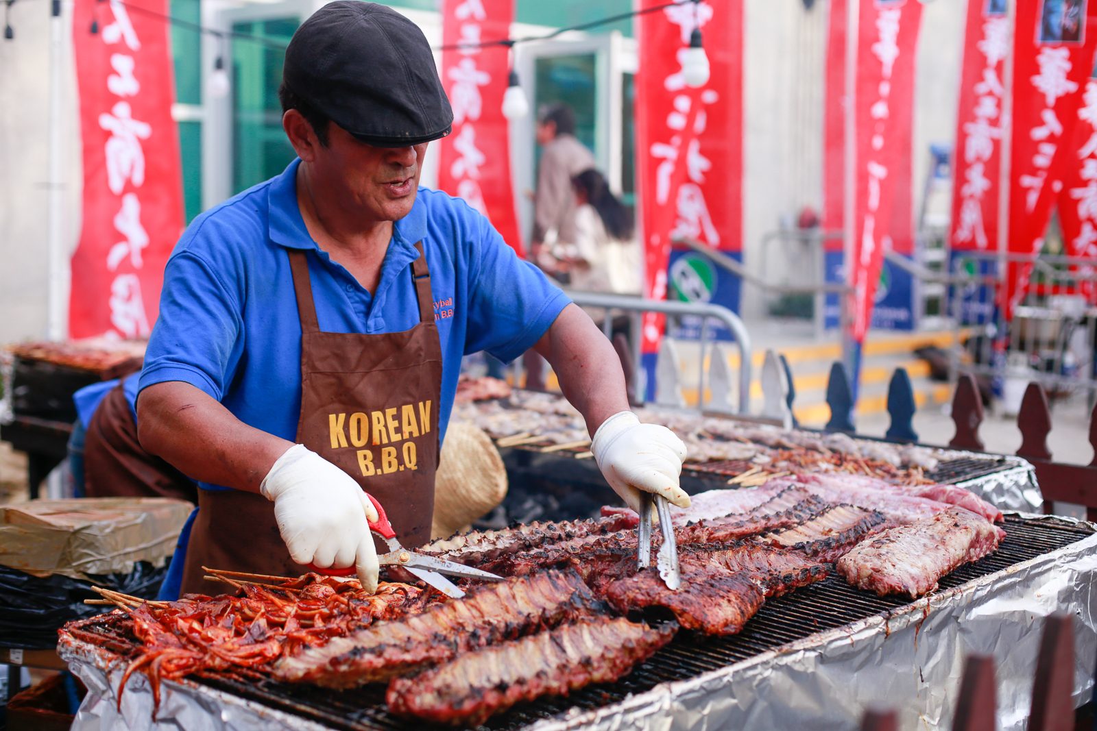 Korean BBQ vendor grilling at an outdoor booth